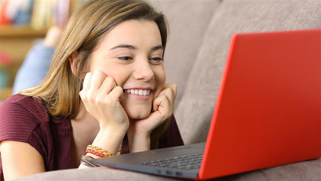 Happy woman looking at a laptop screen